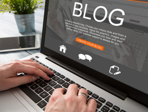 Person typing a blog post on their laptop.
