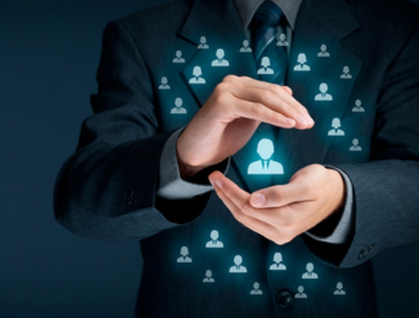 Man in a business suit holding an image of a person in his hands.