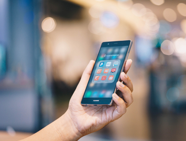 Person holding a cell phone in his hand.